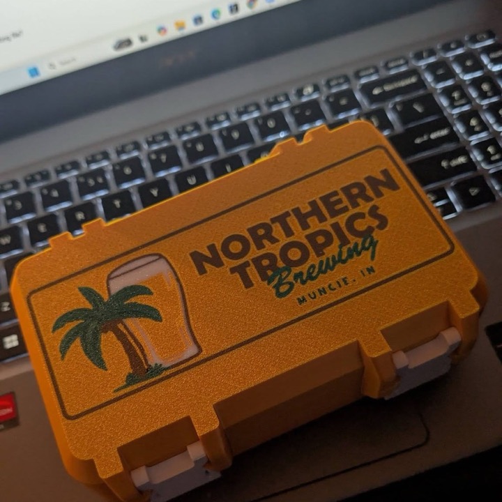 3D printed orange hinged case with a local brewery logo and palm tree, made for a Muncie business
