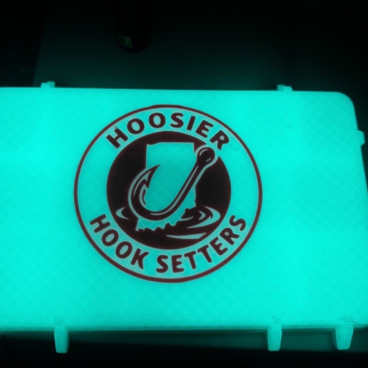 3D printed case glowing green in the dark with a fishing club logo
