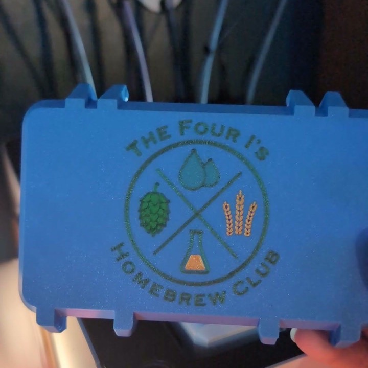 3D printed blue hinged case with a homebrew club crest in multicolor