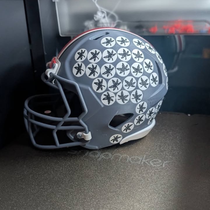 3D printed mini football helmet in grey with red stripe and printed decal details