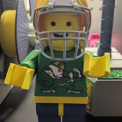 3D printed brick-style football player figure in green and gold with a helmet