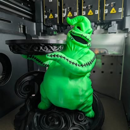 3D printed green monster figure holding a tray